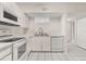 Bright kitchen featuring white cabinets, appliances, and a convenient breakfast bar to the living room at 527 Villa Del Sol Cir # 104, Orlando, FL 32824