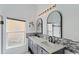 Bathroom featuring a dual sink vanity with marble countertops and modern lighting fixtures at 558 Cadiz Loop, Davenport, FL 33837