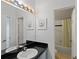 Bright bathroom with a black granite countertop, white cabinets, and a shower/tub combination at 558 Cadiz Loop, Davenport, FL 33837