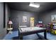 Large game room with an air hockey table, classic arcade games, and gray brick-style wall at 558 Cadiz Loop, Davenport, FL 33837