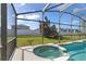 Inviting screened-in spa next to the pool with a view of the backyard at 558 Cadiz Loop, Davenport, FL 33837