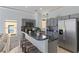 Modern kitchen with gray cabinets, granite countertops, and stainless steel appliances with seating at the island at 558 Cadiz Loop, Davenport, FL 33837