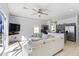 Bright and airy living room with a ceiling fan, light-colored walls, and a view of the kitchen at 558 Cadiz Loop, Davenport, FL 33837
