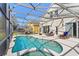 Beautiful screened-in pool and spa area with patio furniture and outdoor kitchen, perfect for entertaining at 558 Cadiz Loop, Davenport, FL 33837