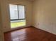 Simple bedroom featuring hardwood floors and a window offering natural light and views at 5918 Stratton Ln, Orlando, FL 32808