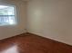 Minimalist bedroom with hardwood floors, a single window, and basic electrical outlets at 5918 Stratton Ln, Orlando, FL 32808