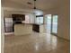 Open kitchen area with stainless steel refrigerator, granite countertops, and a view to the patio at 5918 Stratton Ln, Orlando, FL 32808