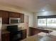 Kitchen with stainless steel appliances, dark wood cabinets, and granite countertops beneath a bright window at 5918 Stratton Ln, Orlando, FL 32808