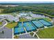 Aerial view of community with pool, tennis courts, playground, and wooded preserve at 6129 Citrus Grove Ct, St Cloud, FL 34771