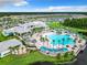 Community aerial view featuring a resort-style pool complex with palm trees, cabanas, and lush landscaping at 6129 Citrus Grove Ct, St Cloud, FL 34771