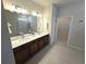 Bathroom featuring double sinks, a large mirror, and tiled floors at 6129 Citrus Grove Ct, St Cloud, FL 34771