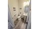 Small bathroom with a pedestal sink, toilet, and decorative wall hangings at 6129 Citrus Grove Ct, St Cloud, FL 34771