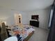 Well-lit bedroom with a floral bedspread, tv, and dark wood dresser at 6129 Citrus Grove Ct, St Cloud, FL 34771