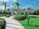 Beautiful clubhouse entrance featuring manicured landscaping, verdant lawns, and a welcoming covered entryway at 6129 Citrus Grove Ct, St Cloud, FL 34771