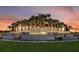 Scenic Del Webb Sunbridge entrance sign with cascading waterfall and tropical palm trees set against a beautiful sunset sky at 6129 Citrus Grove Ct, St Cloud, FL 34771