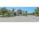 Inviting community entrance gate with a charming guardhouse, elegant brick paving, and lush tropical landscaping at 6129 Citrus Grove Ct, St Cloud, FL 34771