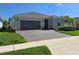 Beautiful home exterior boasting a brick driveway, lush landscaping, and a two-car garage at 6129 Citrus Grove Ct, St Cloud, FL 34771
