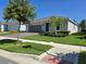 Charming single-story home featuring a well-manicured lawn, mature trees, and a two-car garage at 6129 Citrus Grove Ct, St Cloud, FL 34771