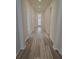 Long hallway featuring gray, wood-look tile flooring and a view of front door with sidelights at 6129 Citrus Grove Ct, St Cloud, FL 34771