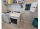 Functional laundry room with modern washer and dryer, storage shelf, and a convenient access door at 6129 Citrus Grove Ct, St Cloud, FL 34771