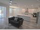 Open concept kitchen and living room with gray, wood-look tile flooring and ceiling fan at 6129 Citrus Grove Ct, St Cloud, FL 34771