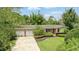 Charming single-story home with a well-manicured lawn and a two-car garage nestled in a green, lush setting at 619 Byron Rd, Winter Park, FL 32792