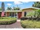 Charming single-story home with a red door nestled in a green, lush setting at 619 Byron Rd, Winter Park, FL 32792