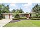 Charming single-story home with a manicured lawn, colorful flower beds, and an attached two-car garage at 619 Byron Rd, Winter Park, FL 32792