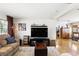 Cozy living room with a large TV, comfortable seating, and natural light, perfect for relaxing and entertaining guests at 619 Byron Rd, Winter Park, FL 32792