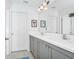 Bathroom featuring double vanity sinks, gray cabinets, white countertops, and modern fixtures at 652 Benoi Dr, Davenport, FL 33896