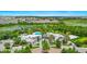 Aerial view of clubhouse, pool, and surrounding palm trees, lake and greenery at 652 Benoi Dr, Davenport, FL 33896