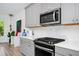 Modern kitchen with white countertops, grey cabinets, stainless steel microwave and gas range cooktop at 652 Benoi Dr, Davenport, FL 33896