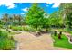 A scenic miniature golf course weaves through lush landscaping and mature trees under a bright blue sky at 652 Benoi Dr, Davenport, FL 33896