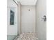Shower with pebble tile floor, modern shower head and glass door at 652 Benoi Dr, Davenport, FL 33896