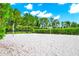 A well-maintained sand volleyball court is surrounded by manicured greenery at 652 Benoi Dr, Davenport, FL 33896