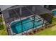 Aerial view of backyard pool and spa with screened enclosure at 7352 Oakmoss Loop, Davenport, FL 33837