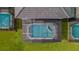 Aerial view of screened-in pool and spa surrounded by lush landscaping at 7352 Oakmoss Loop, Davenport, FL 33837
