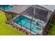 Aerial view of a screened pool and spa, with an outdoor dining area at 7352 Oakmoss Loop, Davenport, FL 33837