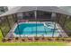 Aerial view of pool and spa under enclosure with grill and patio set at 7352 Oakmoss Loop, Davenport, FL 33837