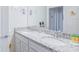 Clean bathroom with double vanity, granite countertop, and ample mirror space at 7352 Oakmoss Loop, Davenport, FL 33837