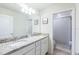 Bathroom with double sink vanity, granite countertop, and tiled shower at 7352 Oakmoss Loop, Davenport, FL 33837