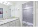 Bathroom featuring single vanity with granite countertop and glass-enclosed shower at 7352 Oakmoss Loop, Davenport, FL 33837