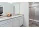 Elegant bathroom featuring a double vanity, granite countertops, and a glass-enclosed shower at 7352 Oakmoss Loop, Davenport, FL 33837