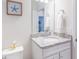 Bathroom featuring a white vanity with granite countertop, toilet, and decorative accents at 7352 Oakmoss Loop, Davenport, FL 33837
