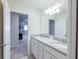 Bright bathroom featuring double sinks, granite counters, and white cabinetry at 7352 Oakmoss Loop, Davenport, FL 33837