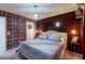 Bedroom features a wooden accent wall, unique wallpaper, and decor at 7352 Oakmoss Loop, Davenport, FL 33837