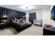 Stylish bedroom featuring a dark accent wall, plush bedding, and themed decor at 7352 Oakmoss Loop, Davenport, FL 33837