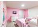 A cheerful bedroom with twin beds, fun pink decor, and ample natural light at 7352 Oakmoss Loop, Davenport, FL 33837