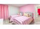 A colorful bedroom with twin beds and playful pink decor, perfect for  at 7352 Oakmoss Loop, Davenport, FL 33837