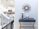 Entryway with a console table and a view into the adjacent kitchen with white cabinets and stainless steel appliances at 7352 Oakmoss Loop, Davenport, FL 33837